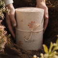 Biourne aus Naturmaterial mit Blumenmotiven für die Erdbestattung