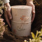 Biourne aus Naturmaterial mit Blumenmotiven für die Erdbestattung
