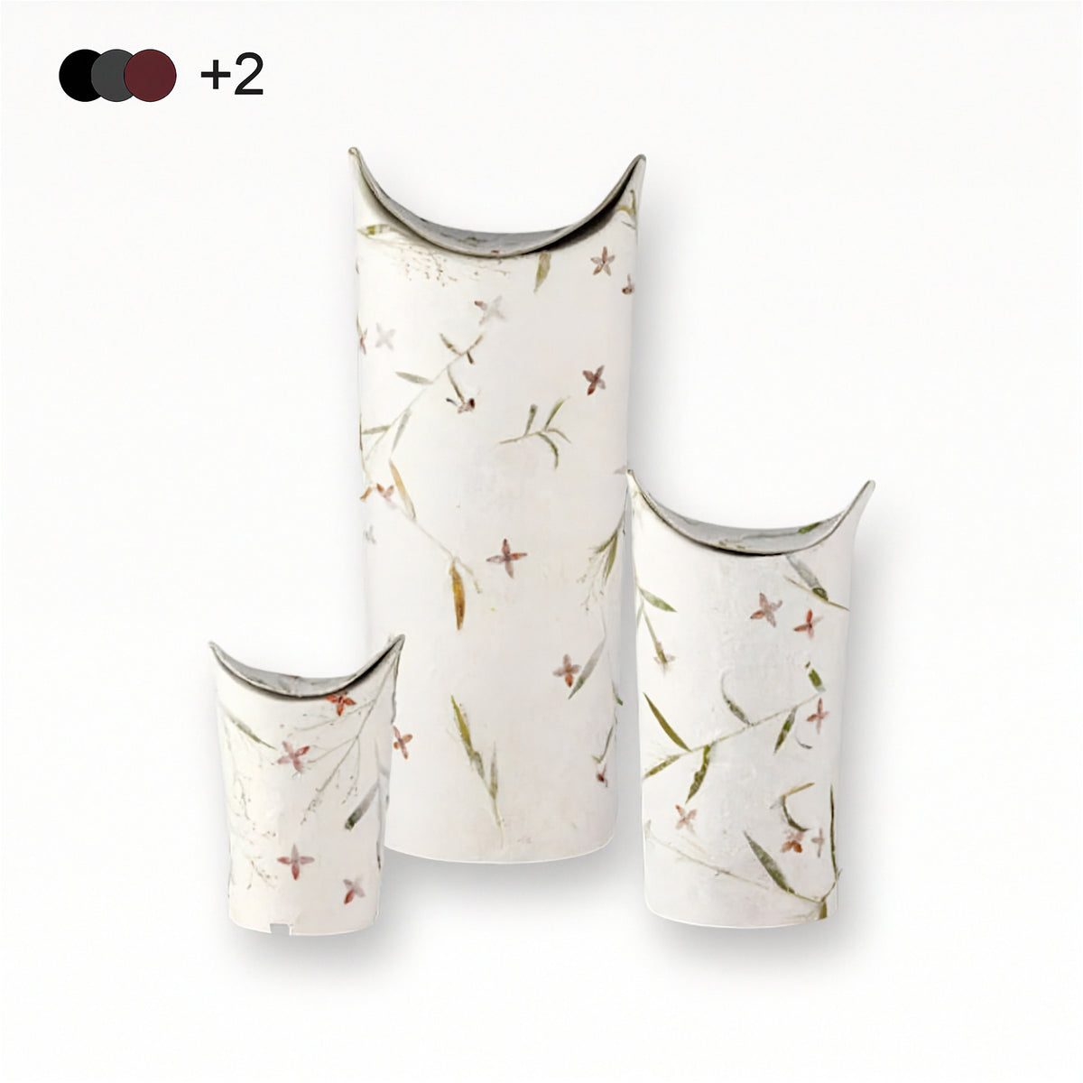 Drei weiße Papierurnen mit zartem Blumenmuster für die Ascheverstreuung